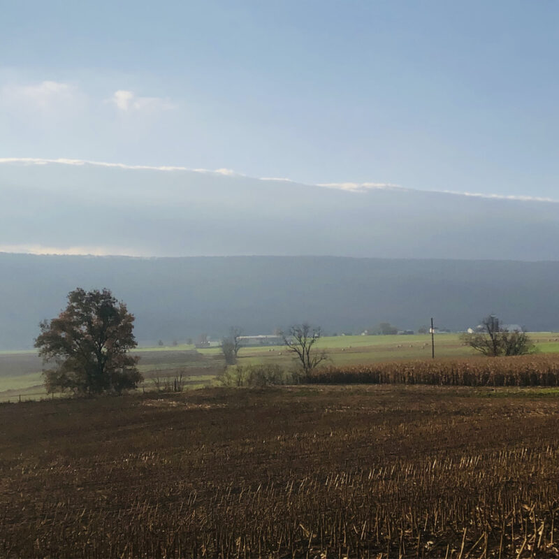 Morning sun peeking over the clouds above a central Pa mountain ridge